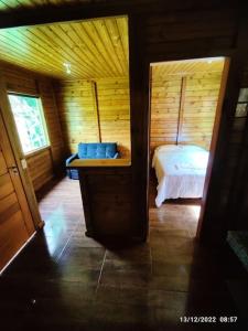 a bedroom with a bed in a wooden cabin at Chalés Maravilha 02 in Alfredo Chaves
