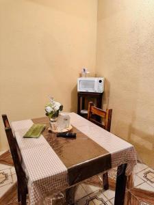 a dining room table with a table and a microwave at Casa Nicolas #1 in San Pedro La Laguna