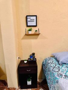 een slaapkamer met een bed en een tafel met een nachtkastje bij Casa Nicolas #1 in San Pedro La Laguna