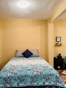 um quarto com uma cama com uma almofada azul em Casa Nicolas #1 em San Pedro La Laguna