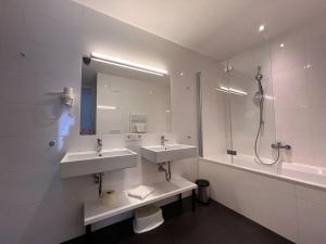 ein Bad mit 2 Waschbecken und einer Dusche in der Unterkunft Residence Bellevue in Erlberg