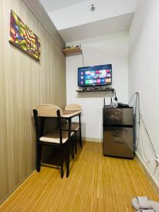 een kamer met een tafel, een tv en een bureau bij Taguig 1 bedroom with balcony Plus Netflix Near Bgc and Airport in Manilla