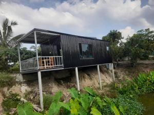 a house on a hill with a black facade at บ้านสวนปวิชญา เกษตรอินทรี in Fang