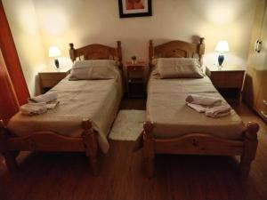 two twin beds in a room with two lamps at La Casa de los Viejos in Minas