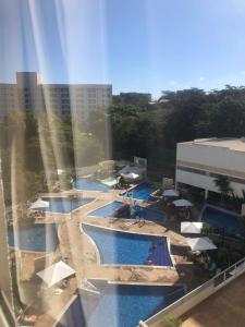 uitzicht op een zwembad in een resort bij Hotel Park Veredas Flat -Vista Piscinas Acesso ao Rio ao lado do Hot Park in Rio Quente