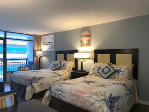 a hotel room with two beds and a balcony at Lee's Myrtle Beach Condo in Myrtle Beach