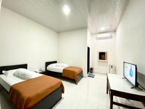 Habitación de hotel con 2 camas y TV en Amadeo Guest House en Ratodena