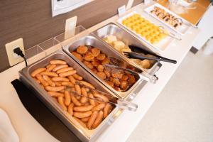 a buffet with several trays of food on a counter at Hotel Frontier Iwaki in Iwaki