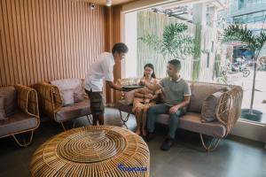 een groep mensen die aan een tafel in een kamer zitten bij Tropicasa Coron Resort & Hotel in Coron