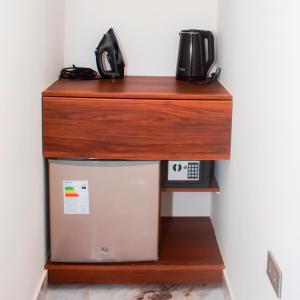 a wooden shelf above a refrigerator with a microwave at Blue Three in Chancay