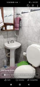 een badkamer met een witte wastafel en een toilet bij Portal del Rio in Puerto Iguazú