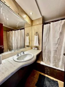 y baño con lavabo, espejo y toallas. en Center Suites, 3 ambientes con cochera opcional en La Plata
