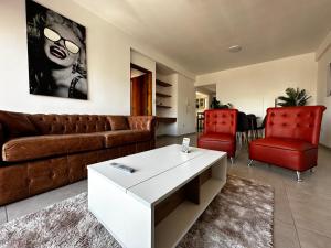 sala de estar con sofá y 2 sillas rojas en Center Suites, 3 ambientes con cochera opcional en La Plata
