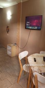 ein Wohnzimmer mit einem TV an der Wand in der Unterkunft Appartements Benedicta in Libreville