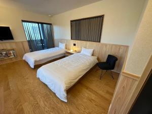 una habitación de hotel con 2 camas y una silla en machiyado Kuwanajuku Edomachi 21, en Kuwana