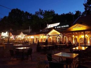 an outdoor restaurant with tables and chairs at night at Welcome House in Eger