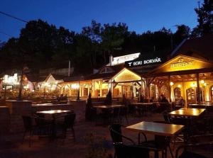 an outdoor restaurant with tables and chairs at night at Welcome House Eger in Eger