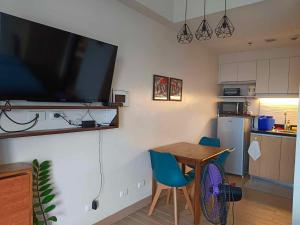 een keuken met een tafel en een televisie aan de muur bij Executive Studio at One Madison Place Iloilo City in Iloilo City