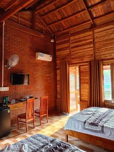 a bedroom with a bed and two chairs in a room at Sunny Eco Lodge in Cat Tien