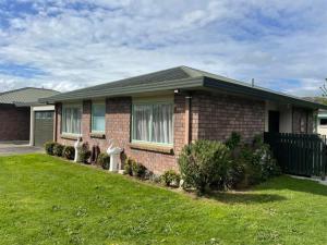 a brick house with a lawn in front of it at POHUTUKAWA PLACE in Matamata