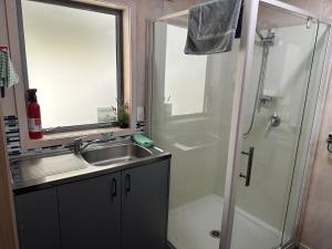 a bathroom with a sink and a shower at Te Mata Bay Seaviews in Tapu