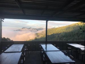 a room with tables and a view of the mountains at ม่านฟ้าฮิลล์ ภูชี้ฟ้า 