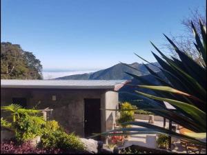 a house with a mountain in the background at ม่านฟ้าฮิลล์ ภูชี้ฟ้า 