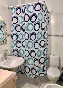 a bathroom with a toilet and a shower curtain at Livi beachfront Apartment in Durrës