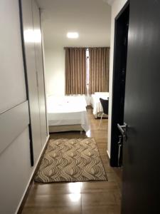 Habitación con cama y puerta con alfombra en Aton Plaza Hotel en Goiânia