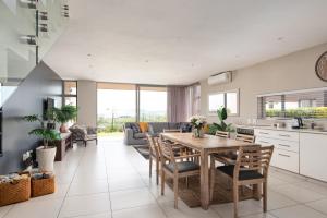 a kitchen and living room with a wooden table and chairs at 56 Zimbali Wedge in Ballito