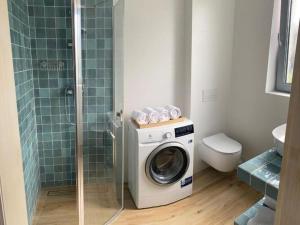 a bathroom with a washing machine and a shower at Storey holiday house for 6 people, Grzybowo in Grzybowo