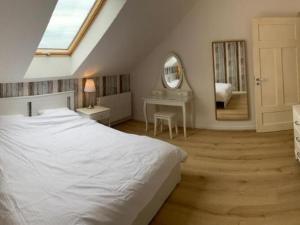 a bedroom with a white bed and a mirror at Storey holiday house for 5 people, Grzybowo in Grzybowo