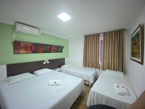 a hotel room with two beds and a window at Aton Plaza Hotel in Goiânia +48 photos