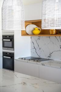 a kitchen with a counter top with a stove top oven at Hyams Beach House A - Brand new lux beach Oasis in Hyams Beach
