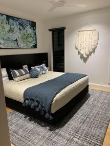 a bedroom with a bed and a chandelier at Hyams Beach House A - Brand new lux beach Oasis in Hyams Beach