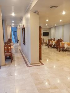 un comedor con mesas y sillas en una habitación en Hotel Alcala del Rio, en Santiago