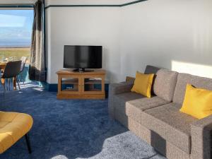 a living room with a couch and a tv at Blue Sands in Morecambe