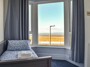 um quarto com uma cama e uma grande janela em Blue Sands em Morecambe