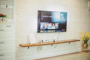 a flat screen tv on a white brick wall at FA House by the Beach in Tanjung Bungah