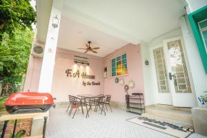 a pink house with a table and chairs at FA House by the Beach in Tanjung Bungah