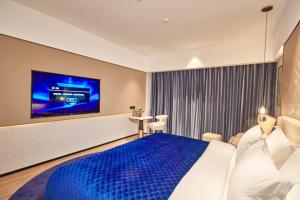 1 dormitorio con 1 cama grande y TV en Vance International Hotel - Linhai Duqiao en Taizhou