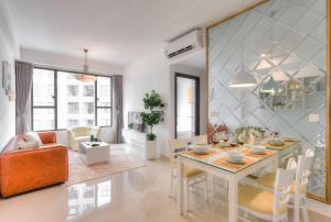 een eetkamer en een woonkamer met een tafel en stoelen bij S Lux Apartment in Ho Chi Minh-stad