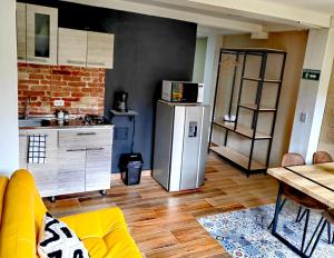 a kitchen with a refrigerator and a table in a room at Confortable Apartamento a 20 mt del Parque Principal in Salento