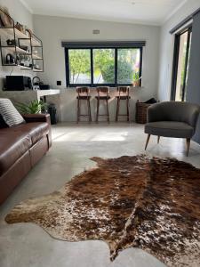 a living room with a couch and a table with stools at Market on 5 in Piet Retief