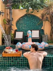 a man laying in the water in a swimming pool at Alsahar Hoi An Boutique Villa in Hoi An