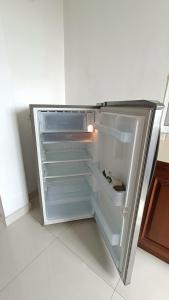 an empty refrigerator with its door open in a kitchen at Smile Hub Kandy Penthouse apartment in Kandy