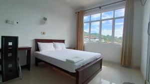 a bedroom with a bed and a large window at Smile Hub Kandy Penthouse apartment in Kandy