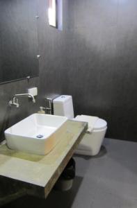 uma casa de banho com um lavatório, um WC e um espelho. em Summer Days em Puerto Princesa