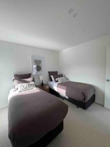 een hotelkamer met 2 bedden in een kamer bij Luxury 3 Bedroom Home With Double Garage in Christchurch