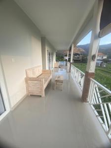 a balcony of a house with a bench and a table at D'A HOUSE in Amed